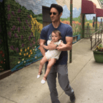 Anthony, Movement Athlete member, carrying his baby daughter — strength for everyday life